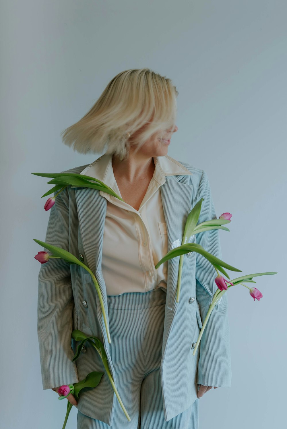 a woman in a suit with flowers in her lap