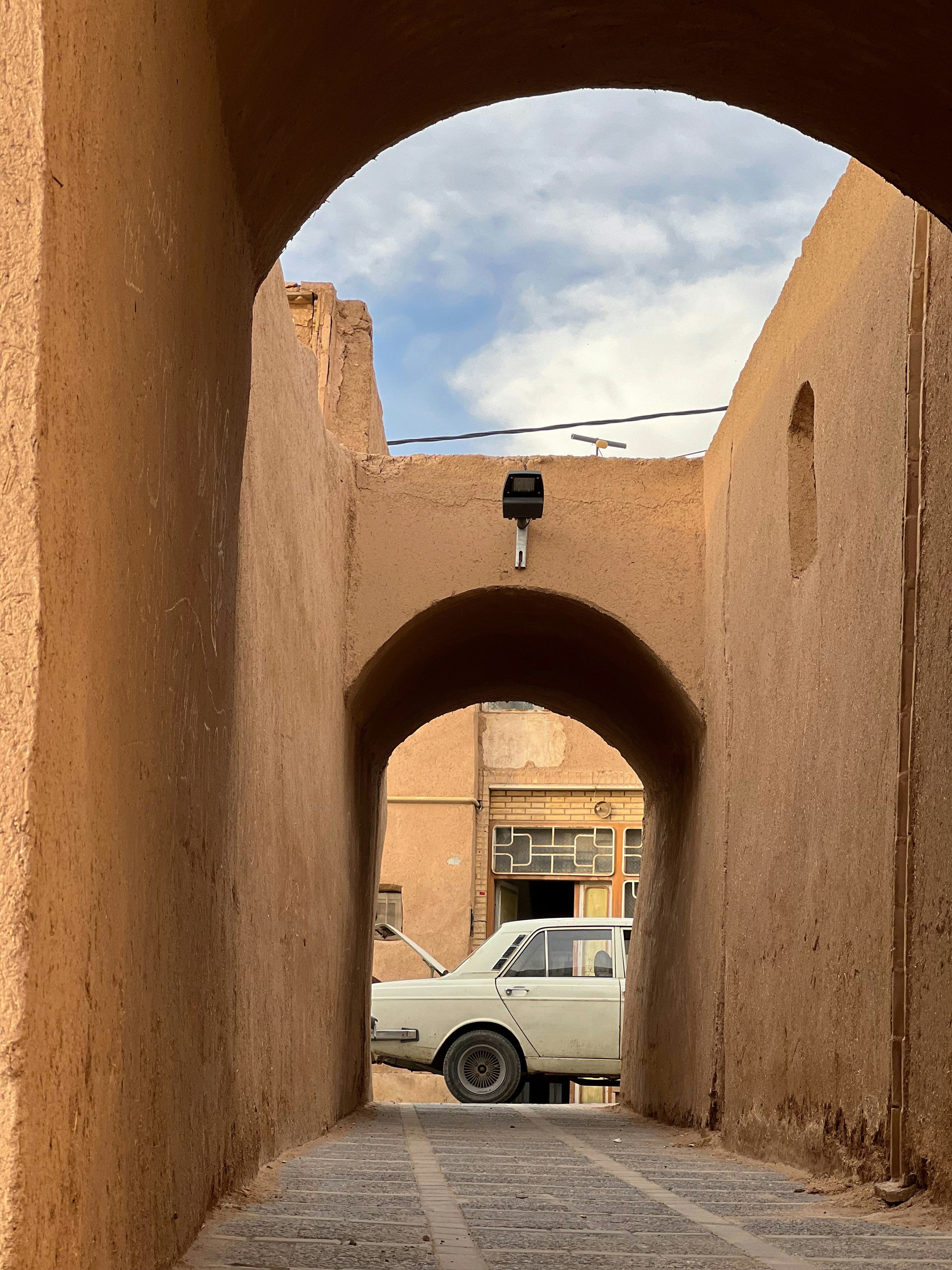 A car is parked in a tunnel between two buildings photo – Free Iran ...