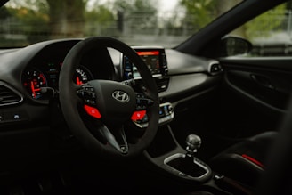 the interior of a car with a steering wheel and dashboard