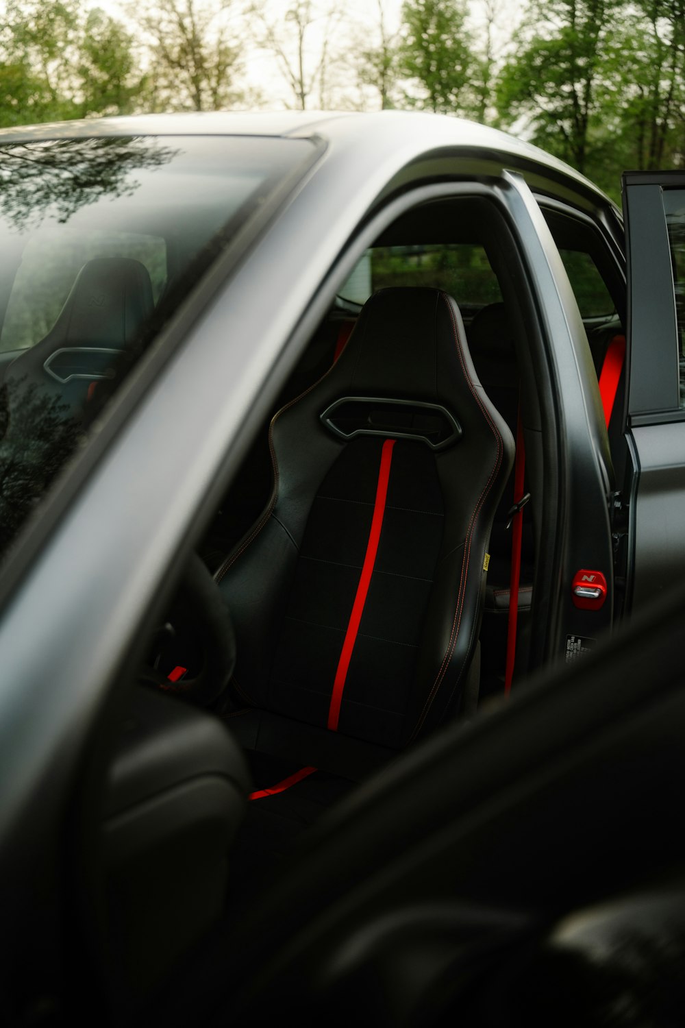 the interior of a black car with red stitching