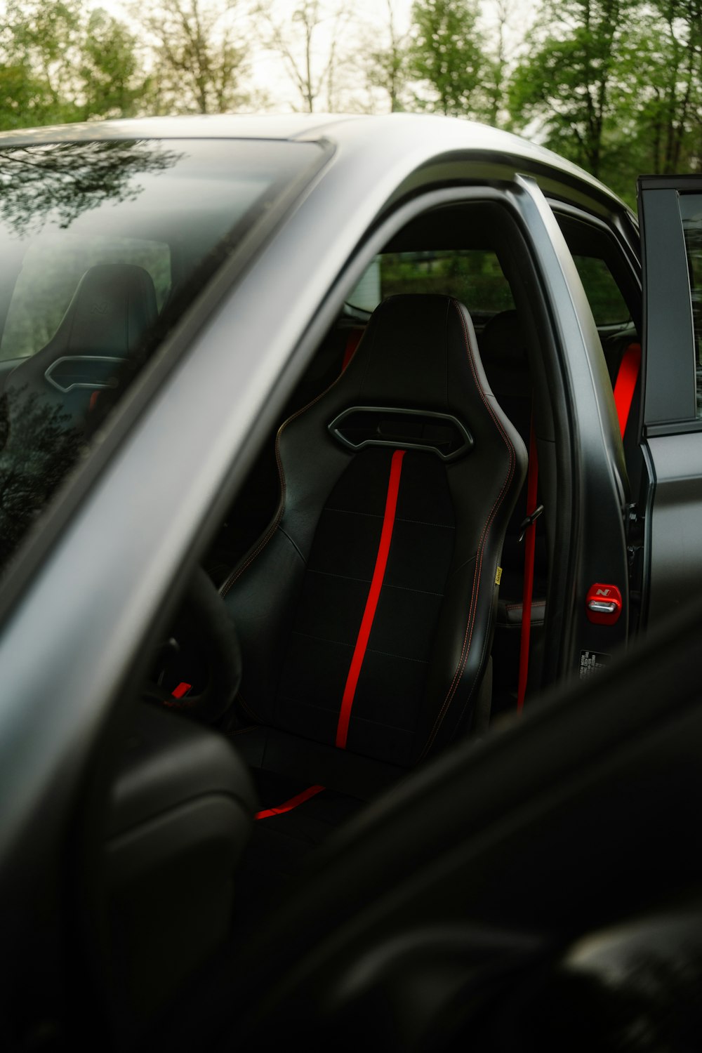 o interior de um carro preto com costura vermelha