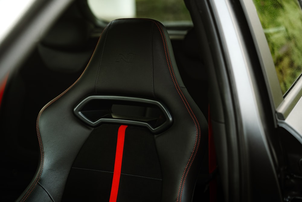 a close up of a car seat with a red stripe