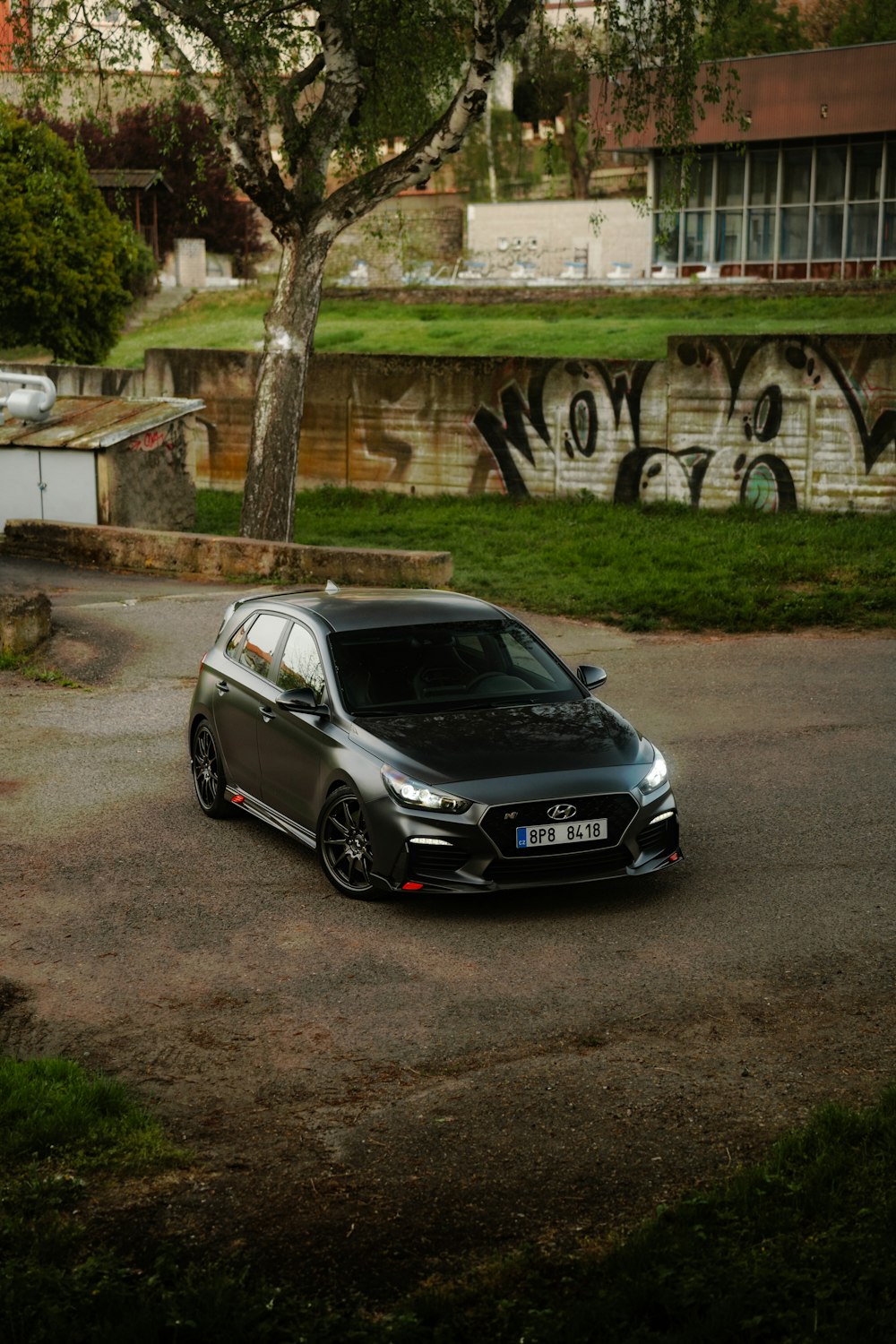 um carro estacionado em um estacionamento ao lado de uma árvore