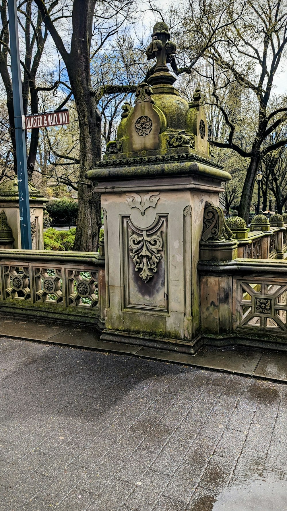 a stone fountain in a park with trees in the background