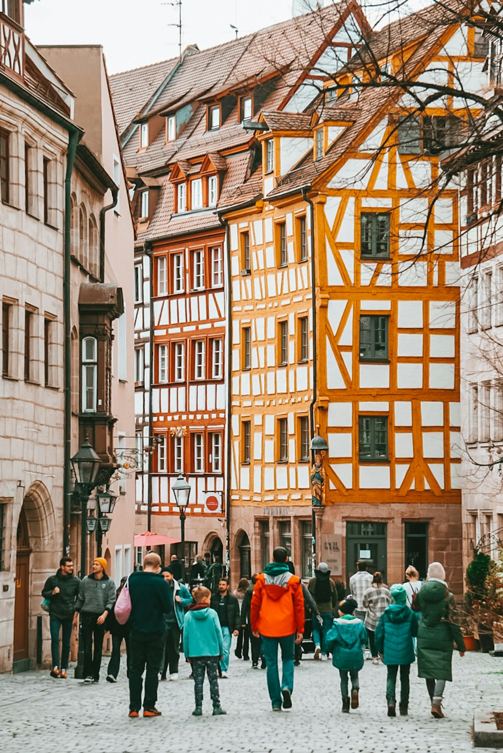 a group of people walking down a cobblestone street