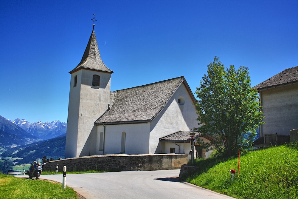uma igreja branca com um campanário em uma colina