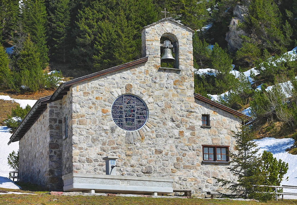 a stone church with a bell on top of it