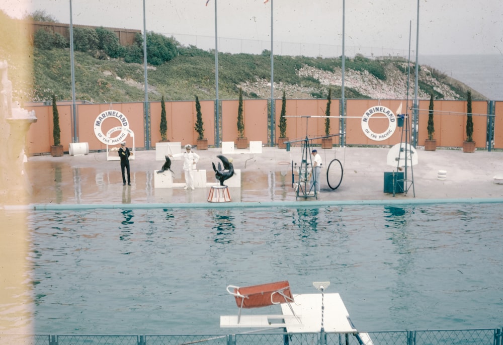 a pool with a few people standing around it