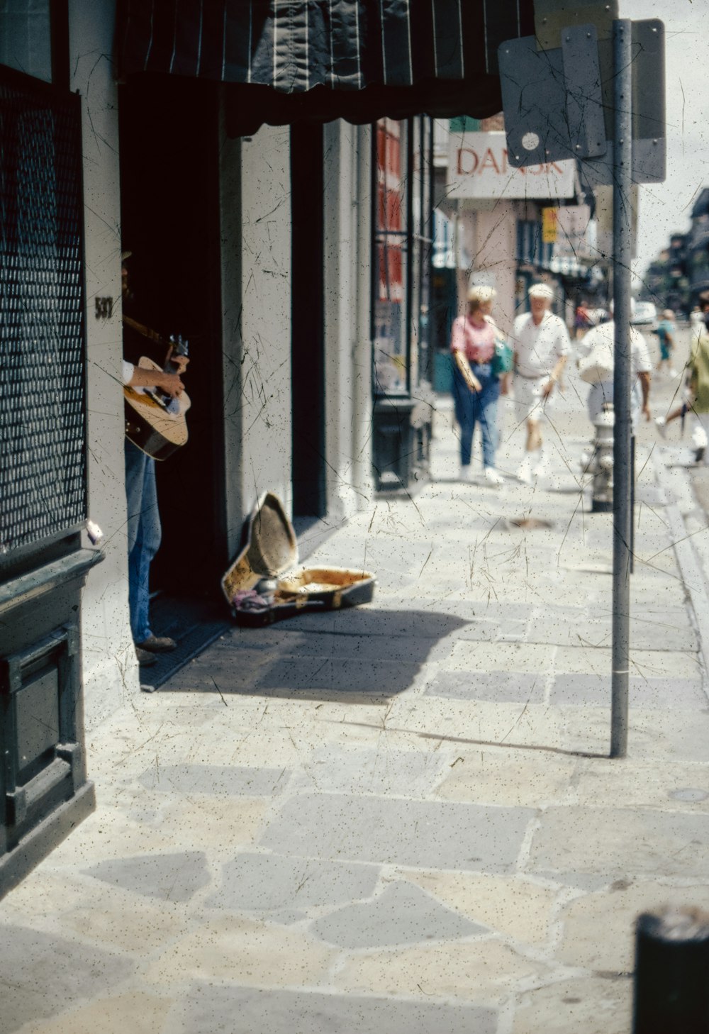 um homem tocando violão em uma calçada