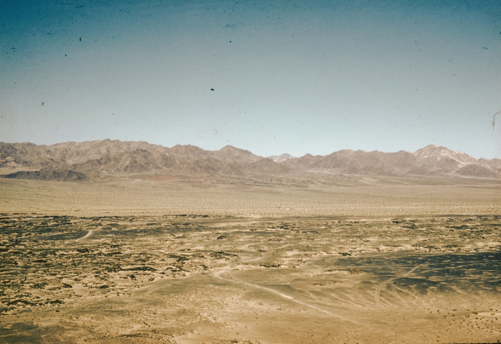 a desert landscape with mountains in the background