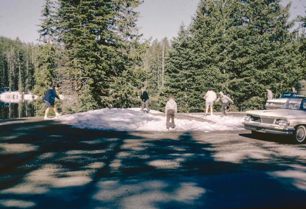 a group of people walking across a snow covered road