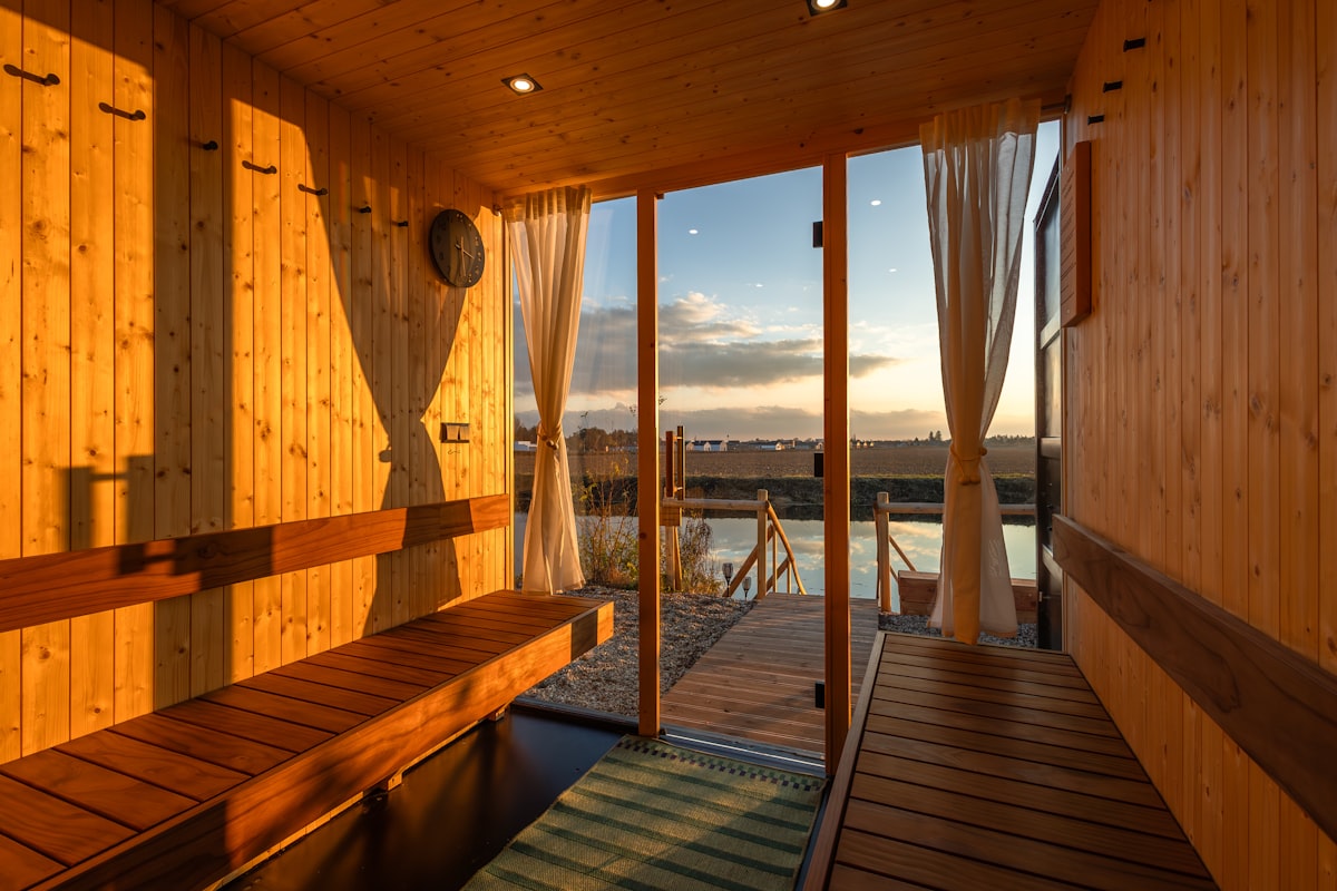 A wooden sauna room with a window looking out over water