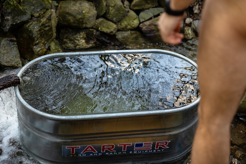 Person entering a cold plunge tub filled with icy water in a modern wellness setting