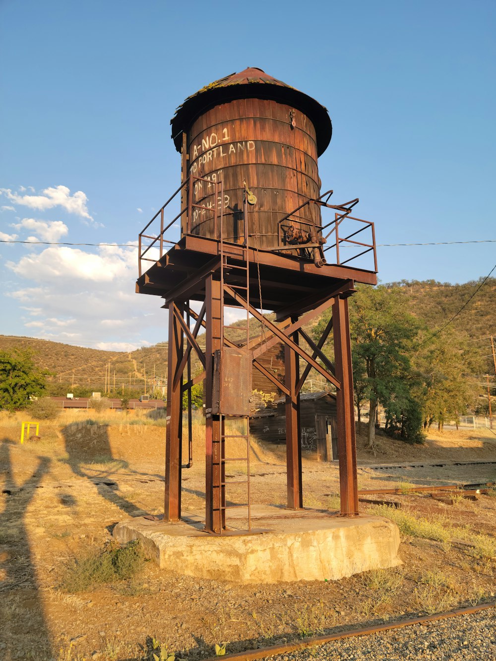 an old rusted water tower in the middle of nowhere