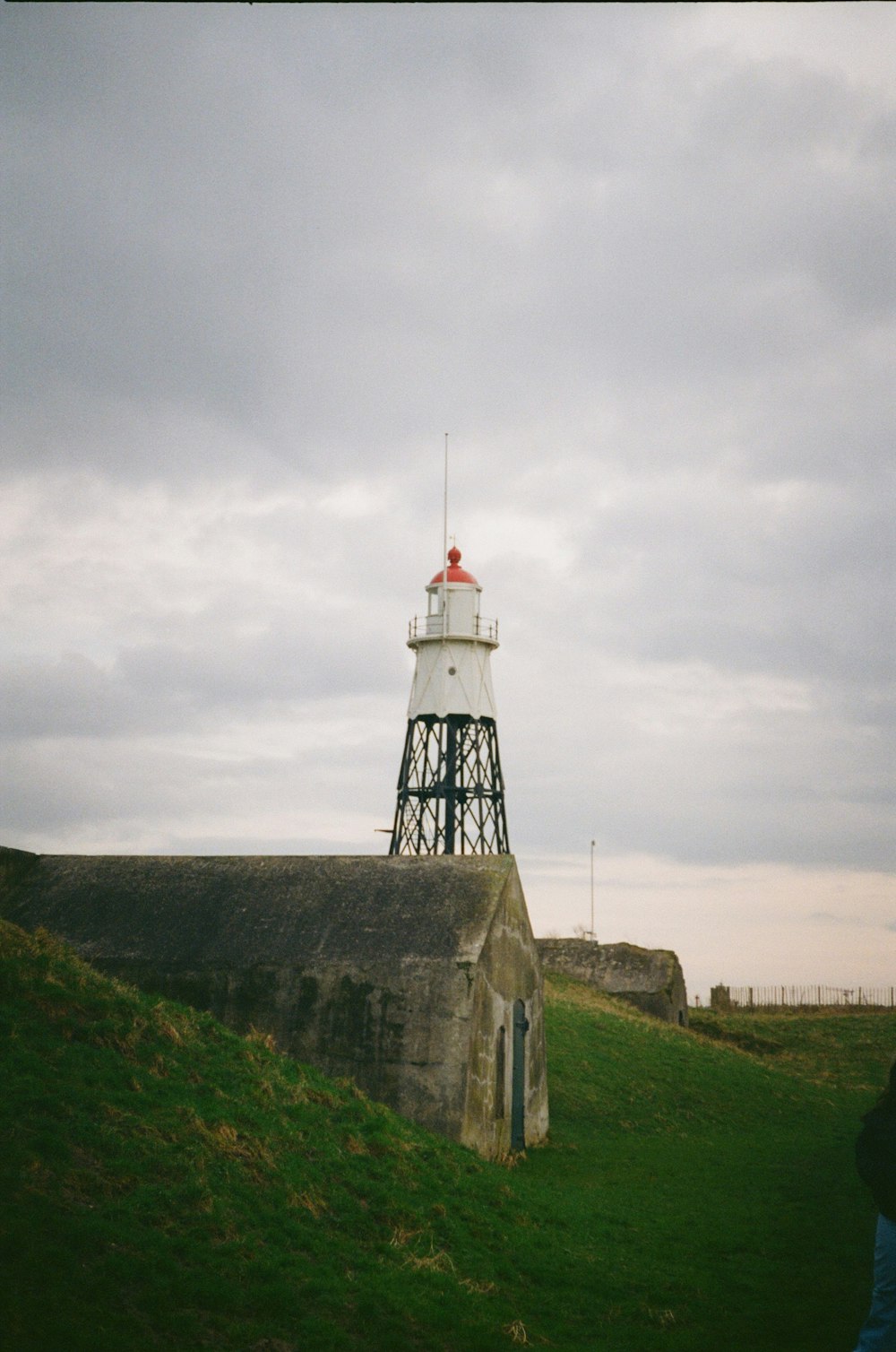 a white and red lighthouse on top of a hill