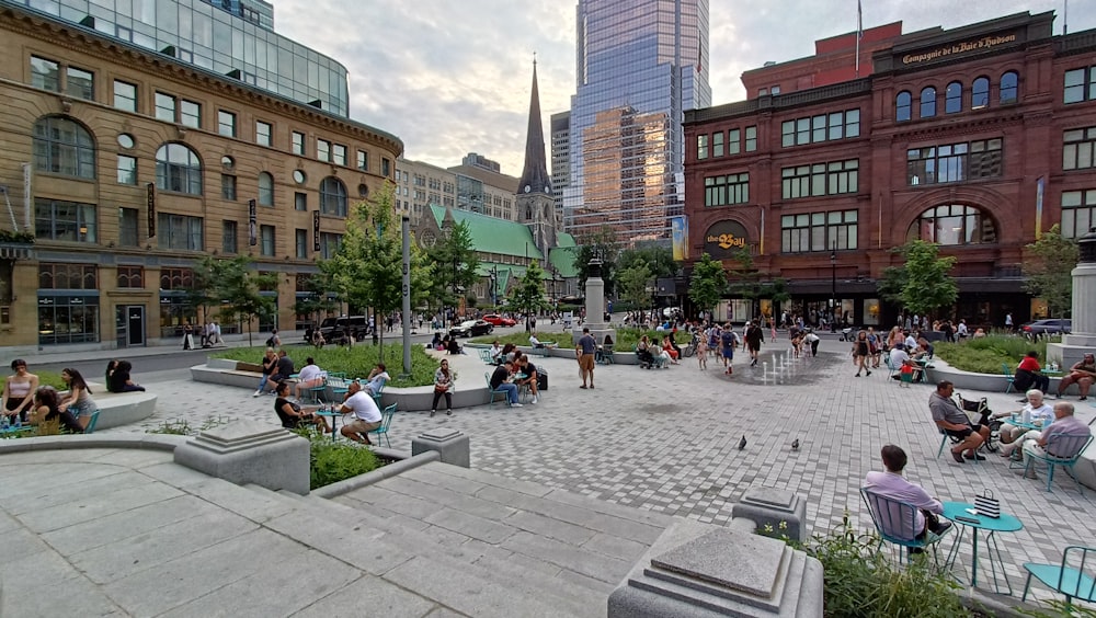 a group of people sitting and walking around a city square