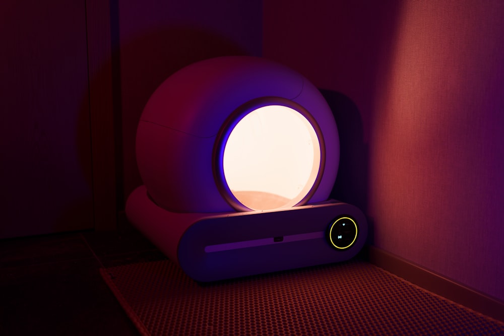 a room with a purple light and a speaker on the floor