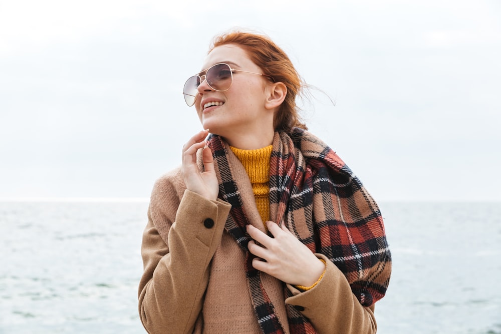 a woman with red hair wearing a plaid scarf