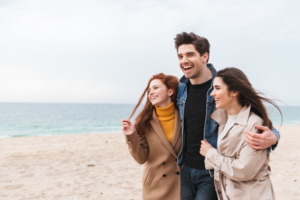 a group of people standing on top of a sandy beach