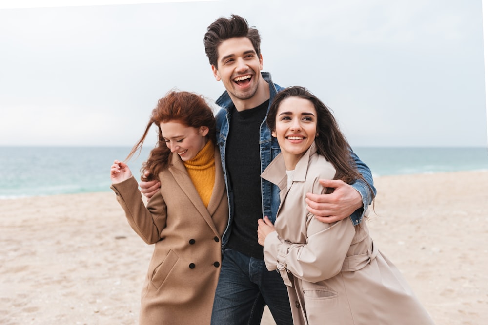 a group of people standing on top of a sandy beach