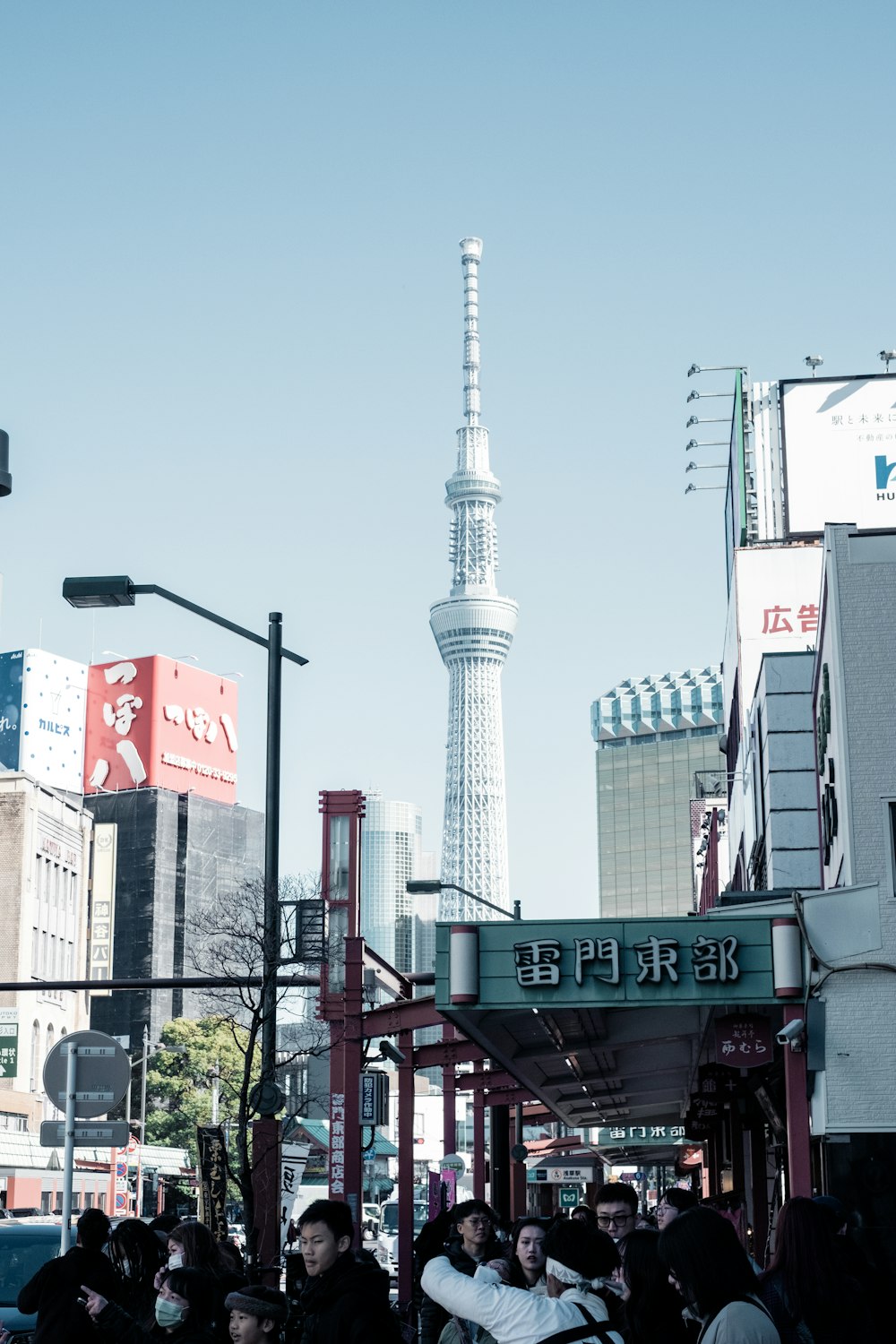 a group of people walking down a street next to tall buildings