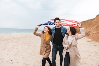 a couple of people standing on top of a sandy beach