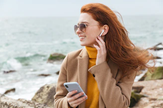 a woman with red hair is talking on a cell phone
