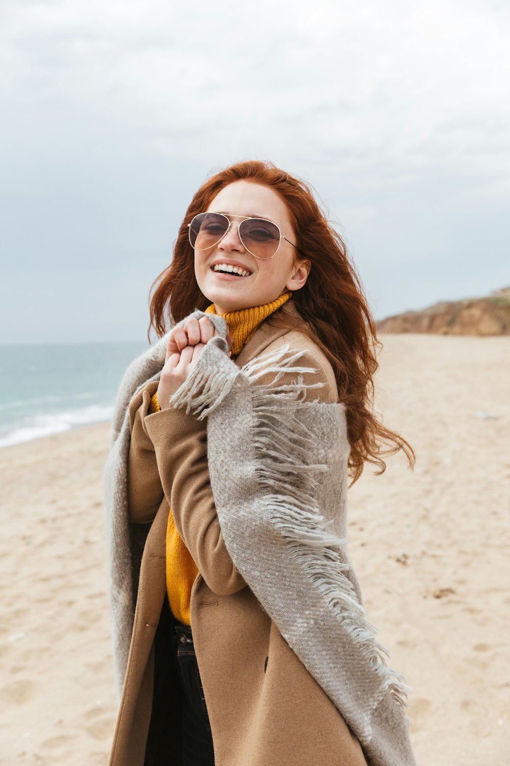 a woman standing on top of a sandy beach