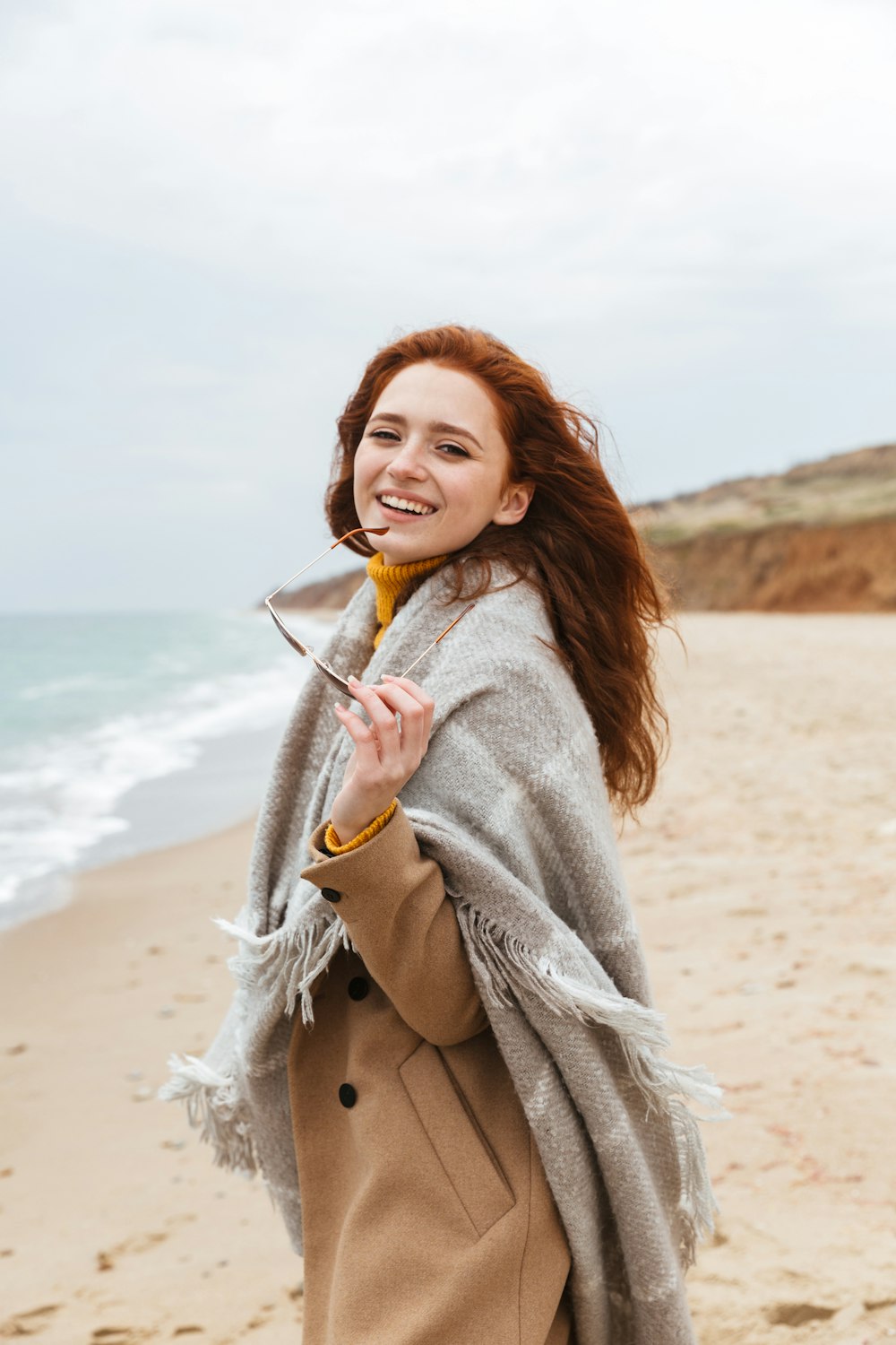 a woman standing on top of a sandy beach