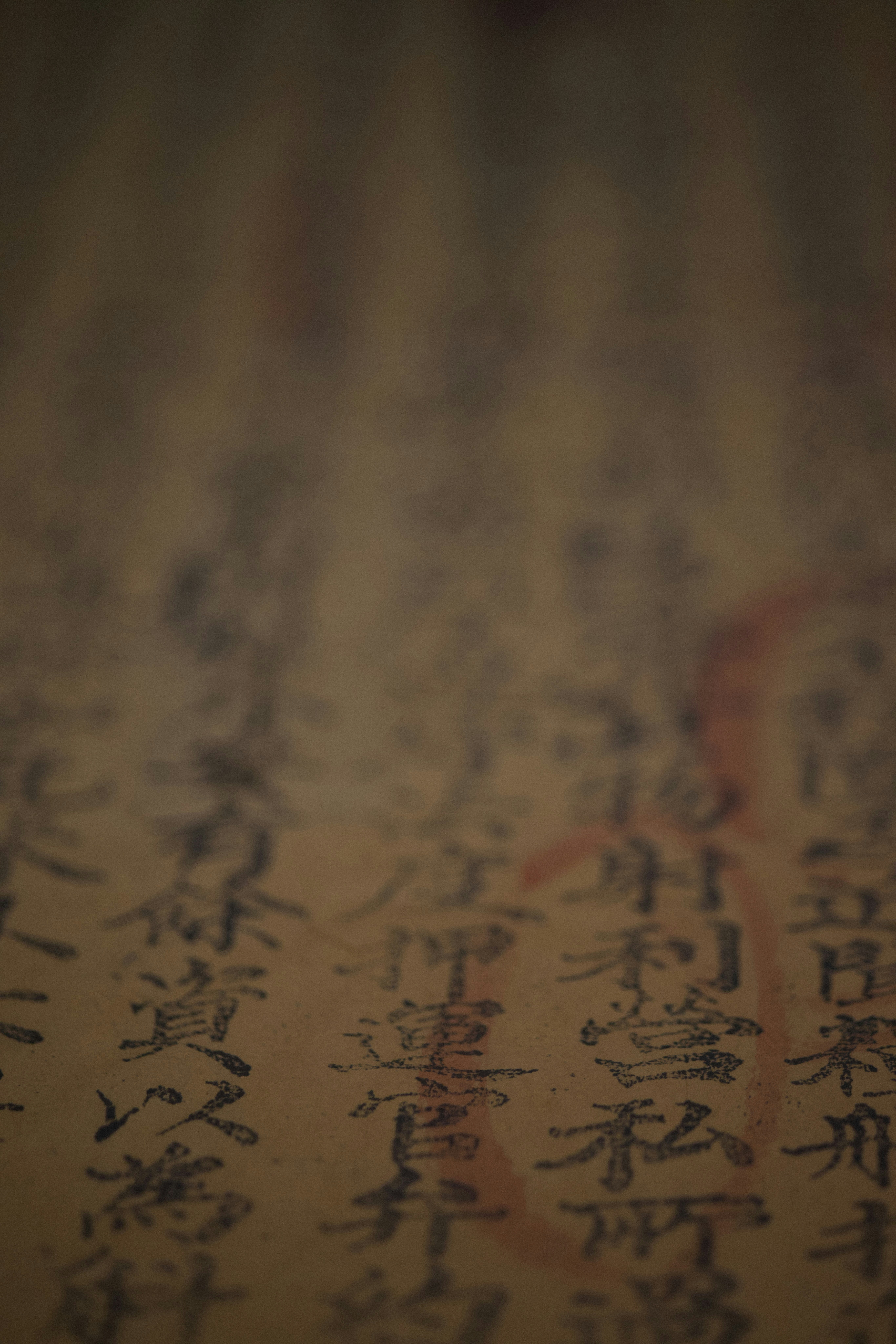 Pergamino antiguo con texto manuscrito en tinta oscura sobre fondo de madera rústica