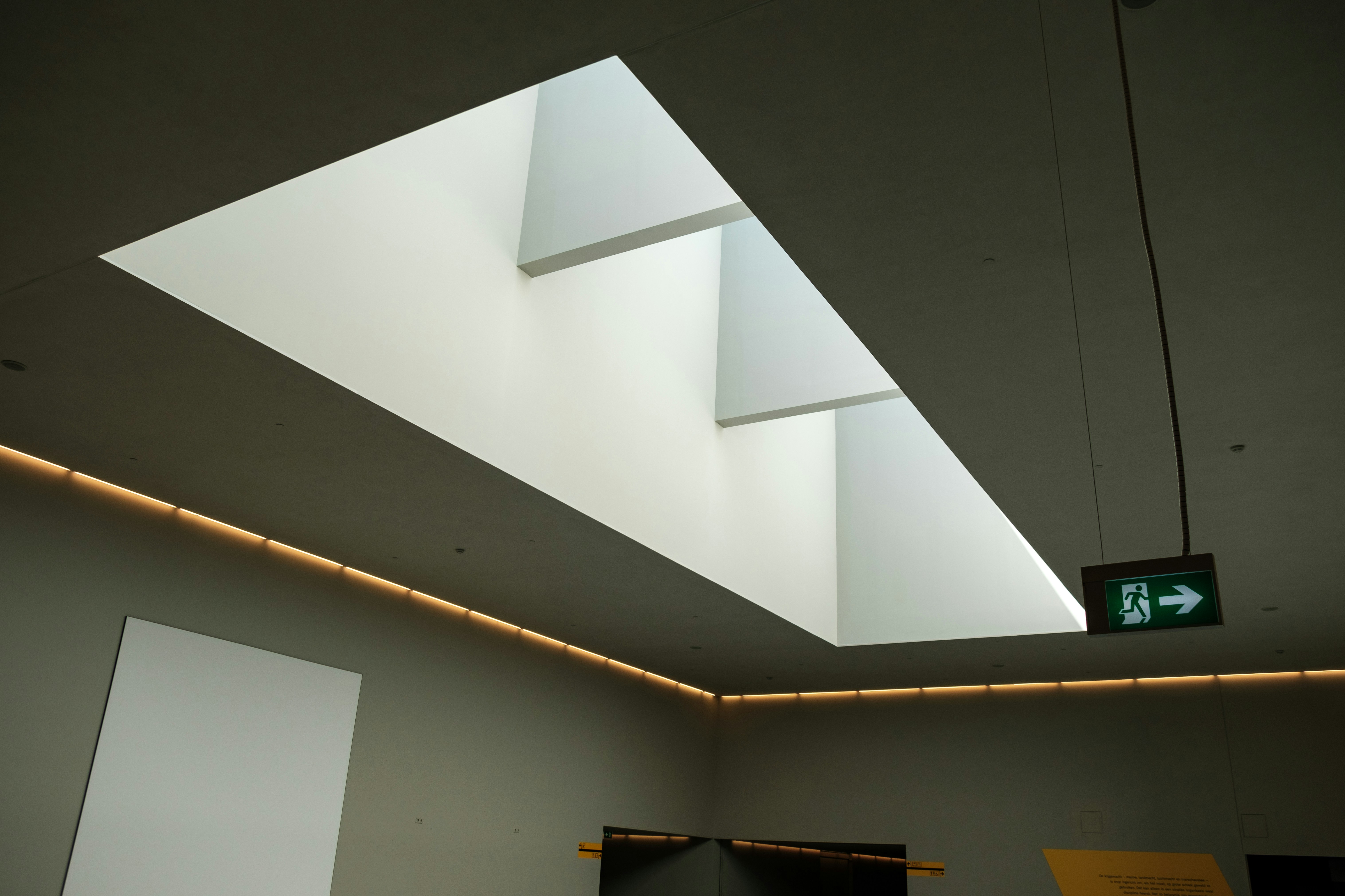 A white room with a skylight and a sign on the wall photo – Free ...