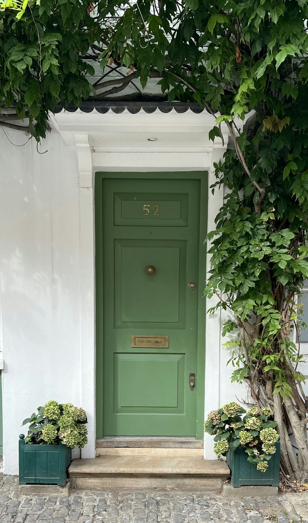 a green door with two planters in front of it