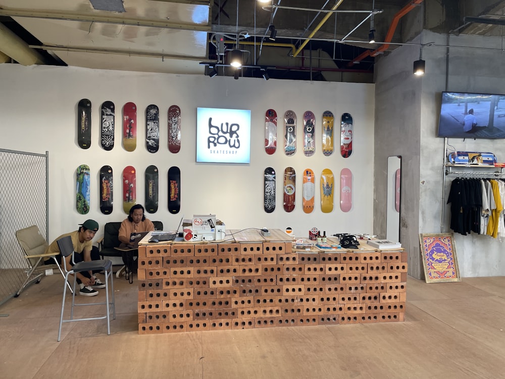 a man sitting in a chair in front of a display of skateboards