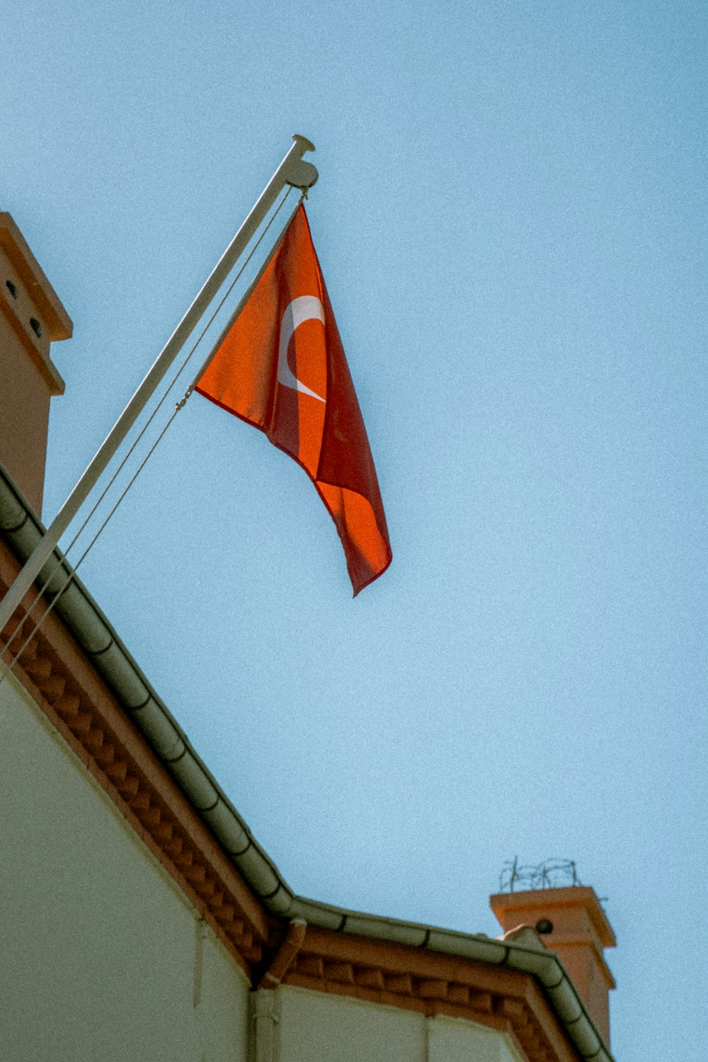 a flag on top of a building with a sky background