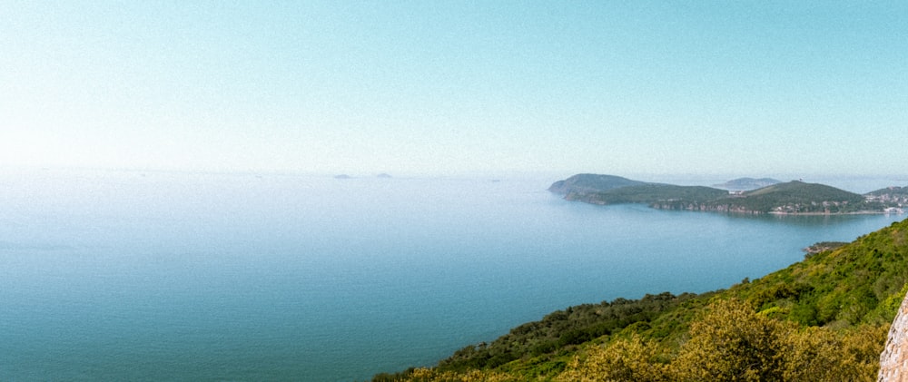 a man sitting on a ledge overlooking a body of water