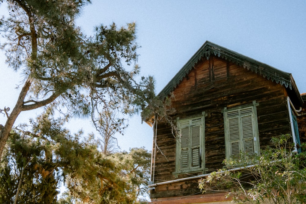 an old wooden house with shutters on the windows