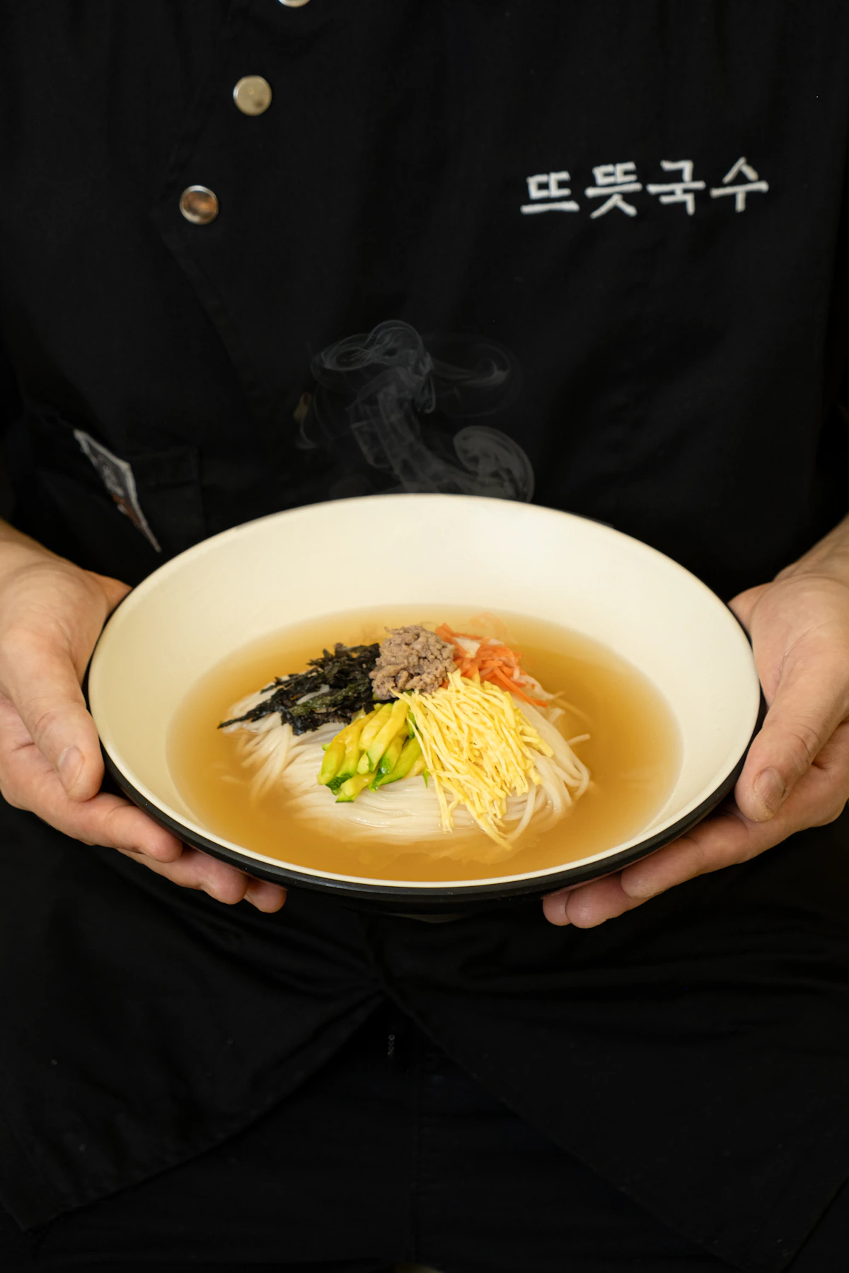 Người phụ nữ đang bưng bát canh nóng hổi trên tay