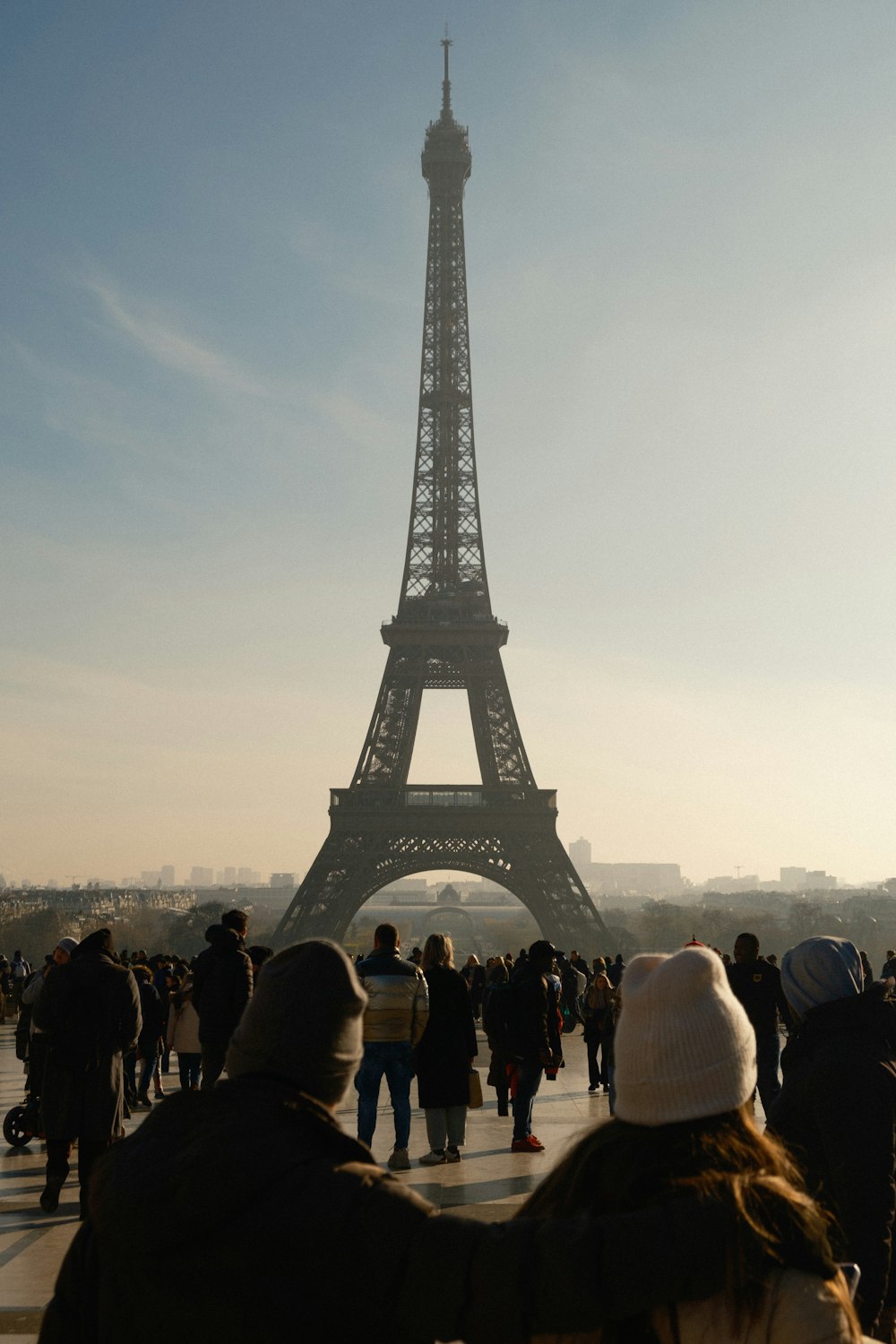 a group of people standing in front of the eiffel tower