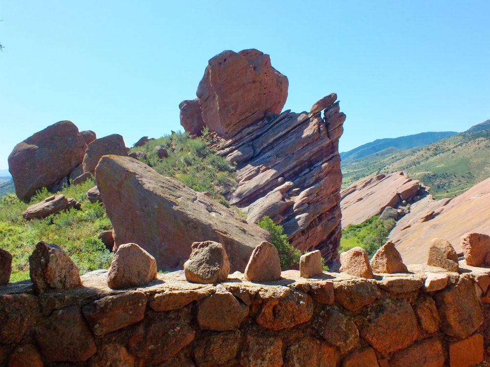 a stone wall with a rock formation in the background