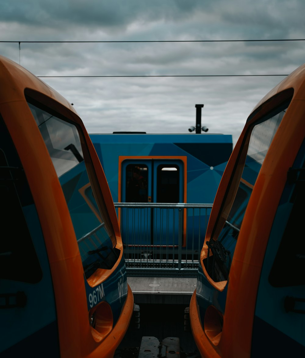 two orange seats facing each other in front of a blue train