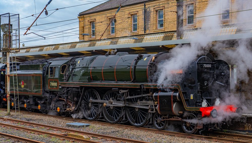 a steam engine train pulling into a train station