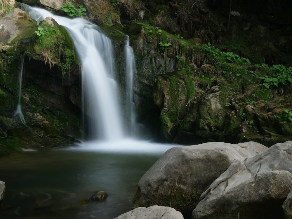 a small waterfall in the middle of a forest