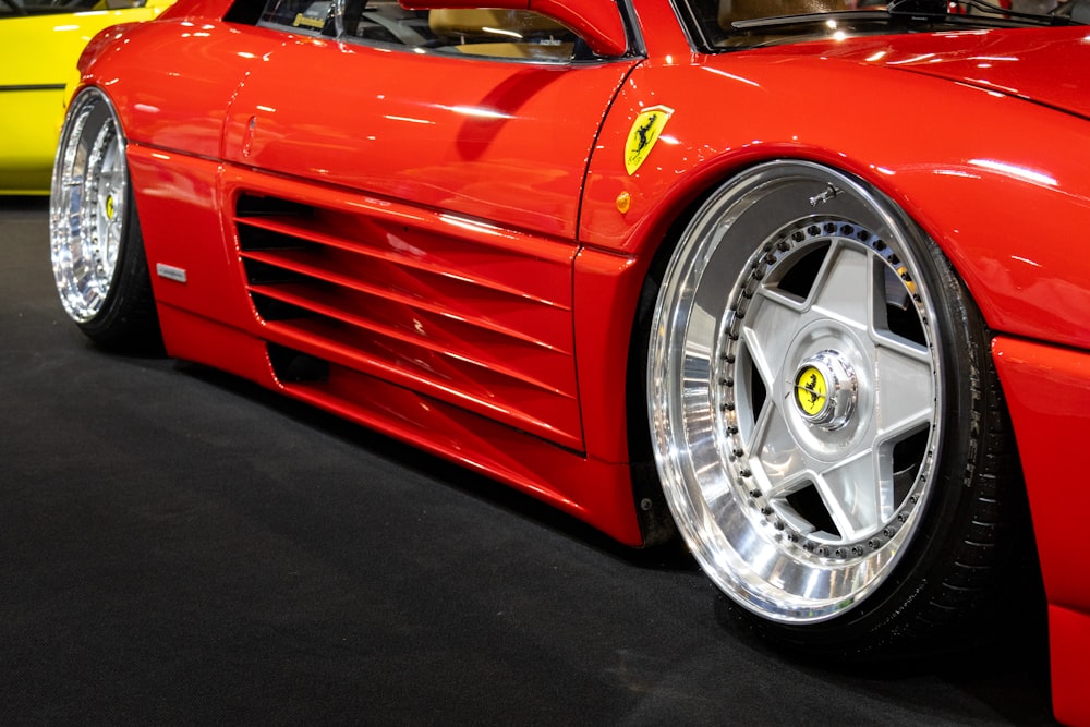 a close up of a red sports car on display