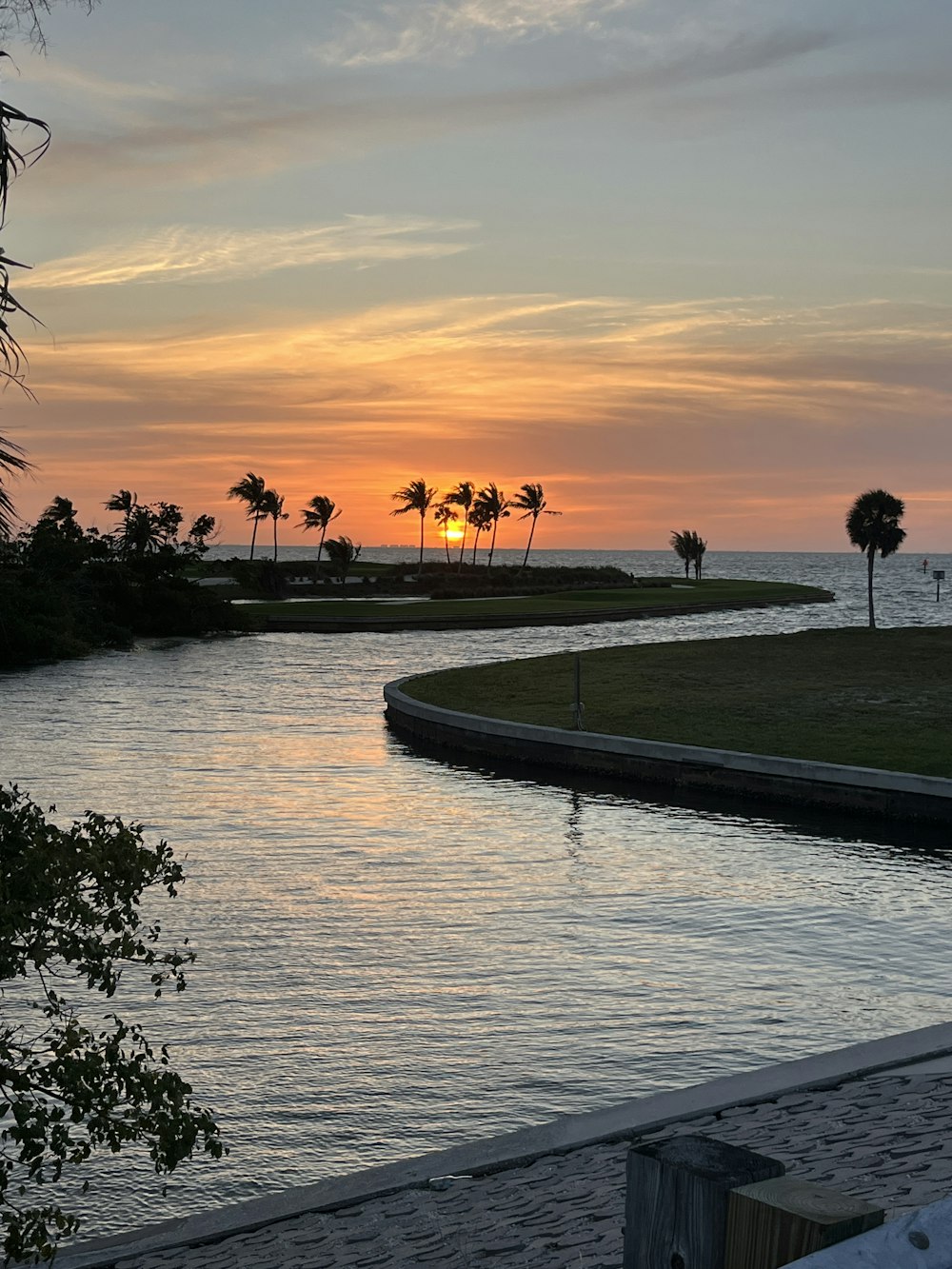 a body of water with a sunset in the background