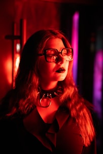 a woman wearing glasses in a dark room