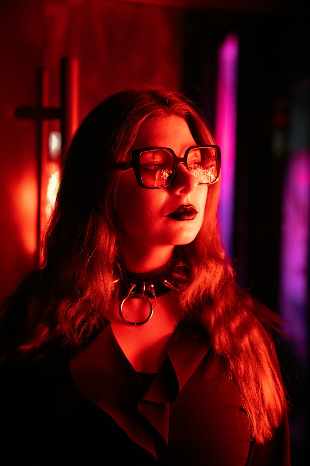 a woman wearing glasses in a dark room