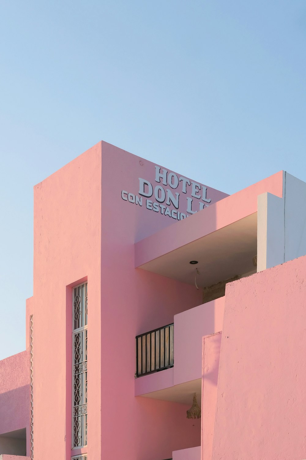 a pink building with a balcony and balconies