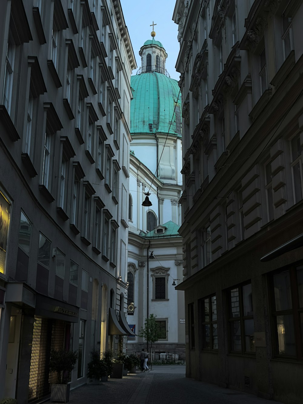 a view of a clock tower from a narrow alley way