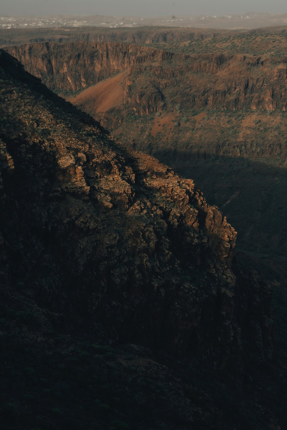 a view of a rocky mountain with a valley in the distance