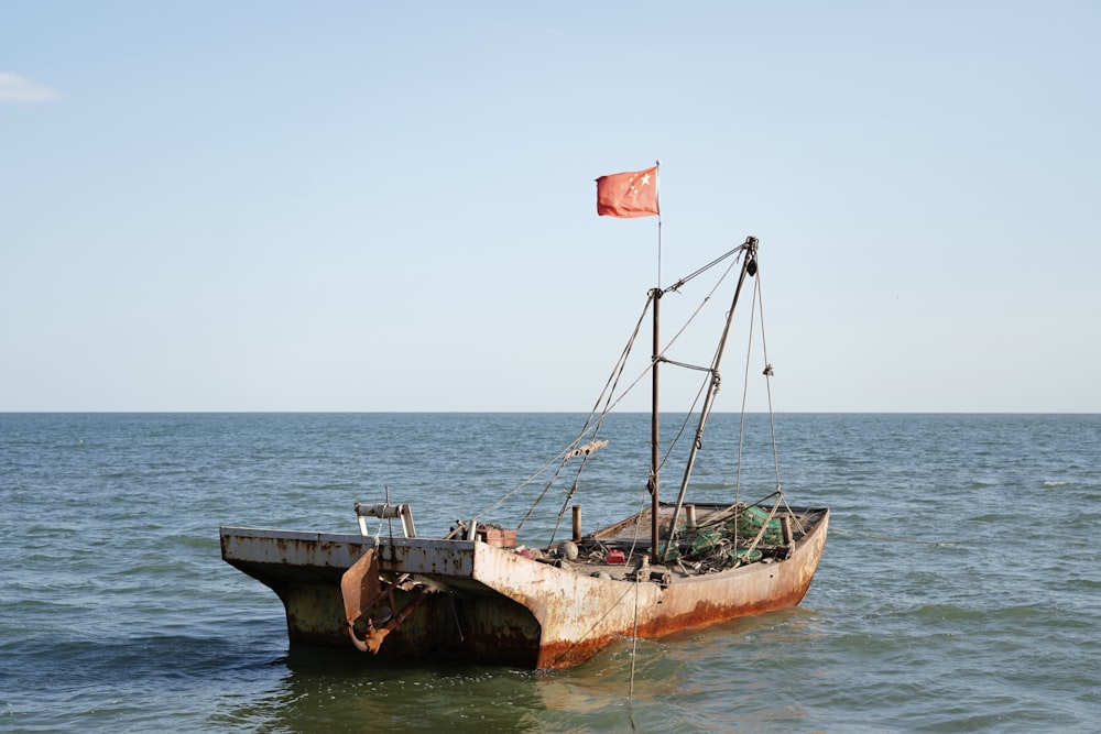 a rusted boat in the middle of the ocean